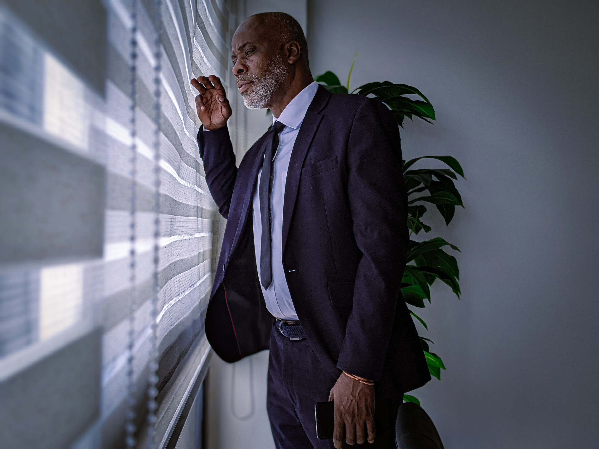 un-homme-daffaires-professionnel-noir-africain-qui-regarde-par-la-fenetre