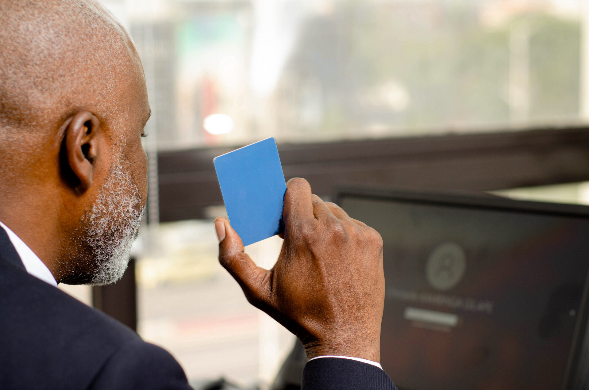 un-homme-noir-africain-qui-tient-une-carte-bancaire-a-la-main-devant-un-ordinateur