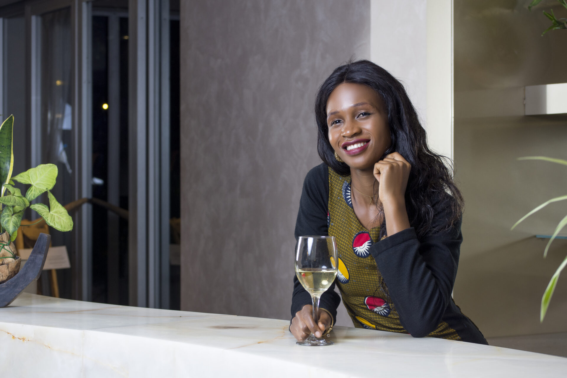 une-jeune-femme-noire-africaine-a-un-bar-buvant-un-verre-de-vin-dans-un-hotel