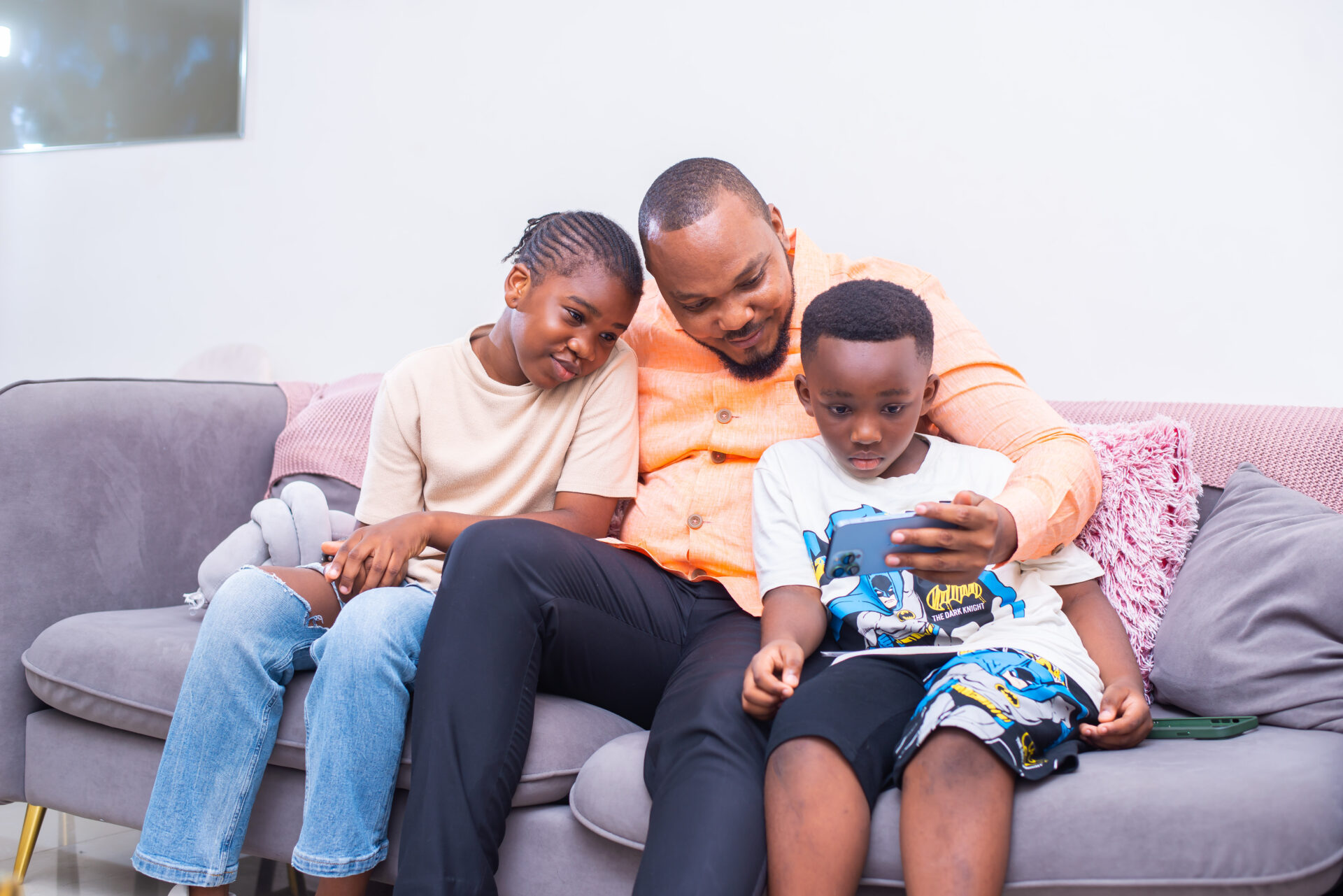 une-famille-unie-assise-sur-un-canape-regardant-lecran-dun-telephone