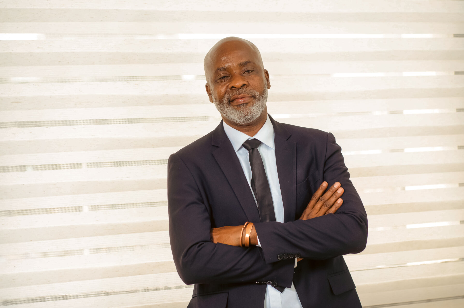 homme-noir-professionnel-dans-son-bureau-qui-croise-les-bras-en-souriant