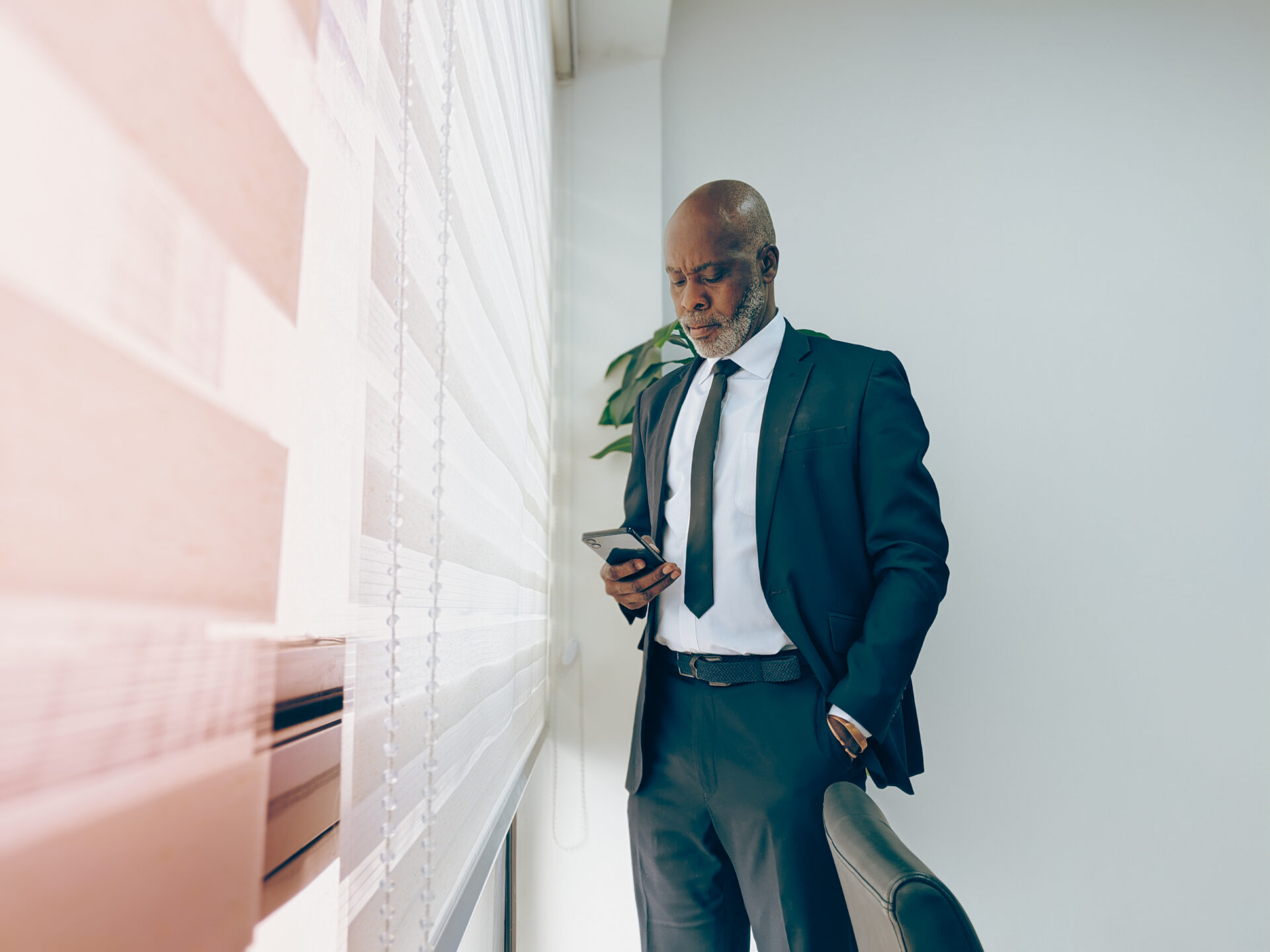 un-homme-professionnel-dans-son-bureau-qui-regarde-son-telephone